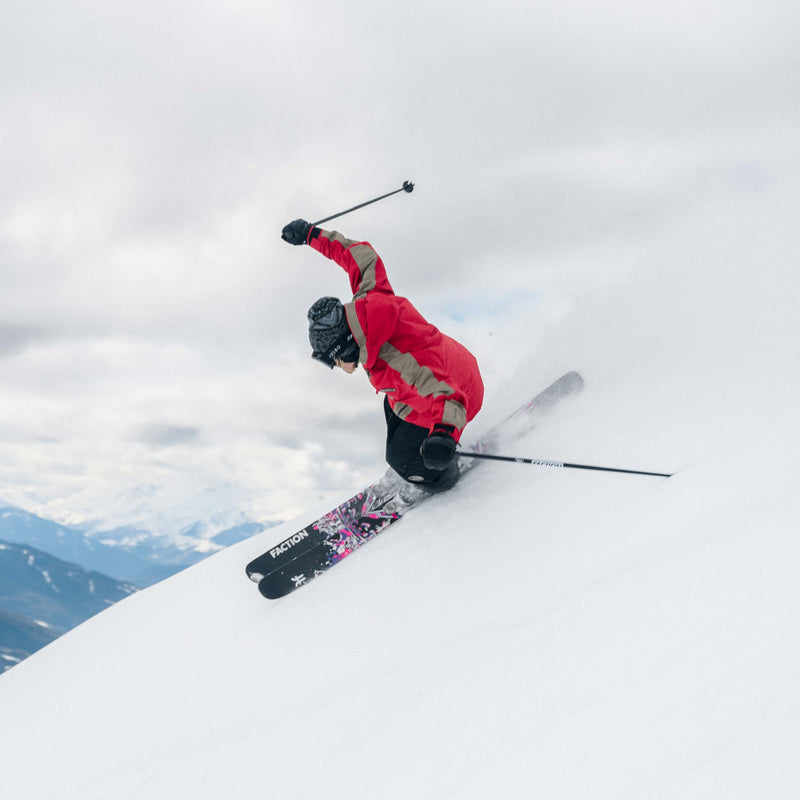 Freeski skier jumping with black and purple all-mountain Freeski Faction Prodigy 3 ski