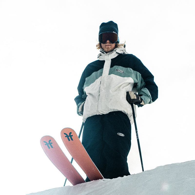 Antti Ollila standing over a snow half-pipe with Faction Prodigy 3 skis.