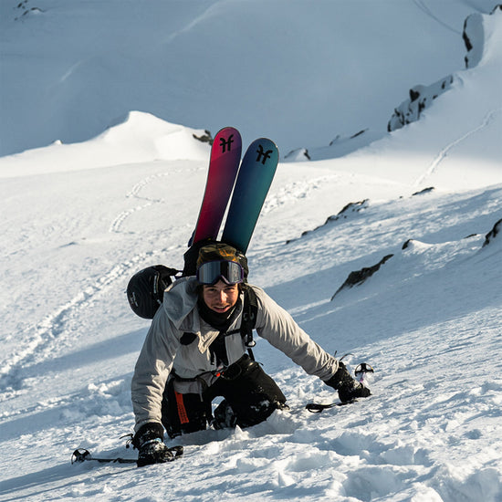 Martin Bender hiking up a mountain face with the Faction Studio 3 skis attached to his backpack.