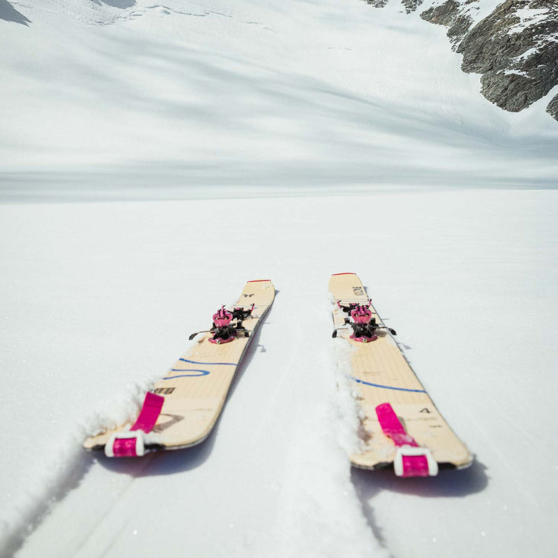 Faction Agent 4 freetouring skis lying on a snowy surface with mountains in the background