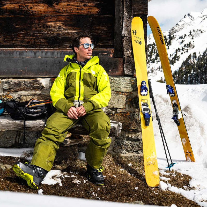 Freeride skier sitting next to yellow Dancer 4 Freeride and powder skis 2026