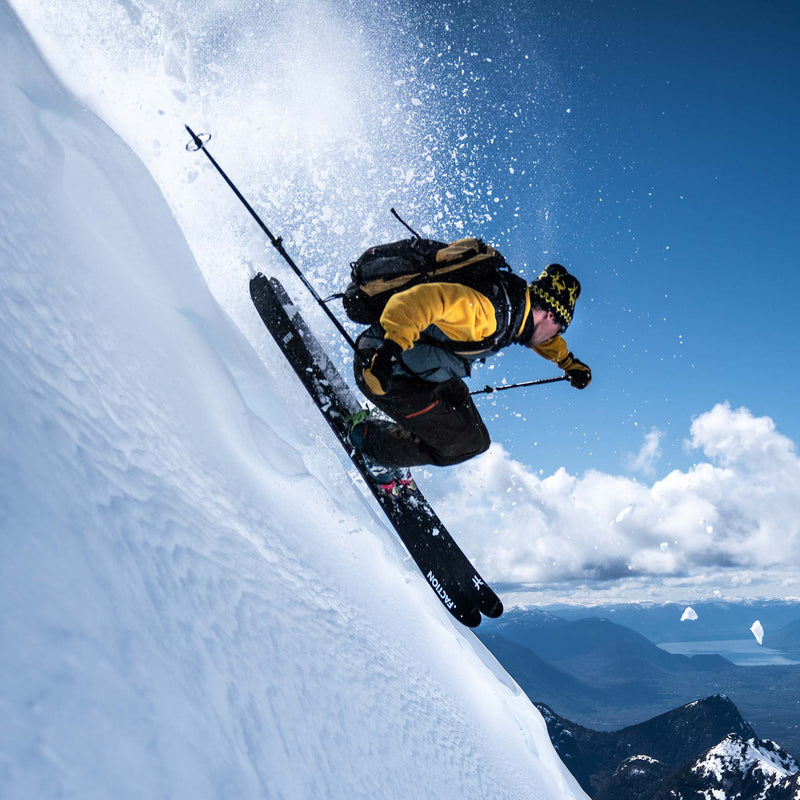 Skier jumping using Faction La Machine 3 black and purple touring skis 2026