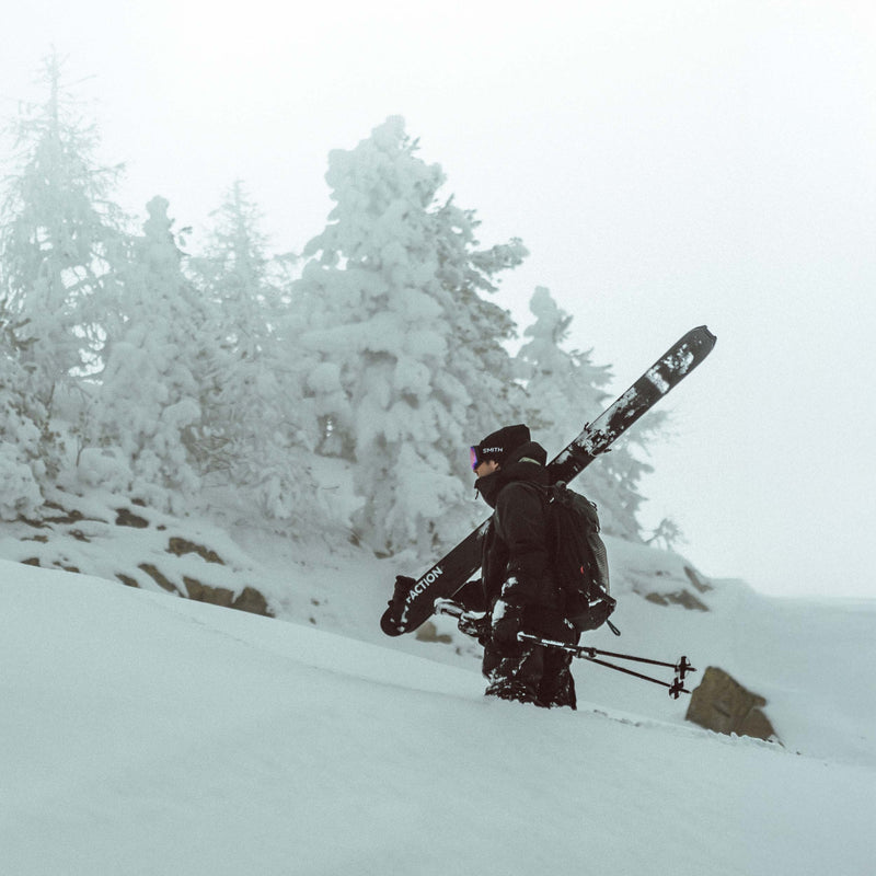 Skier walking in powder with Black free touring powder Faction La Machine 4 skis