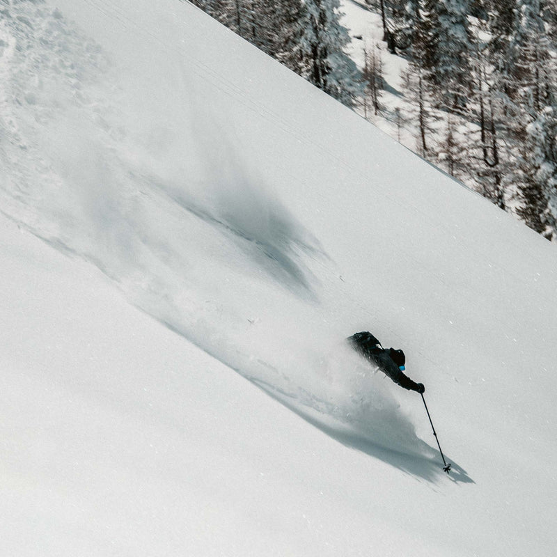 Skier riding powder with Black free touring powder Faction La Machine 4 skis