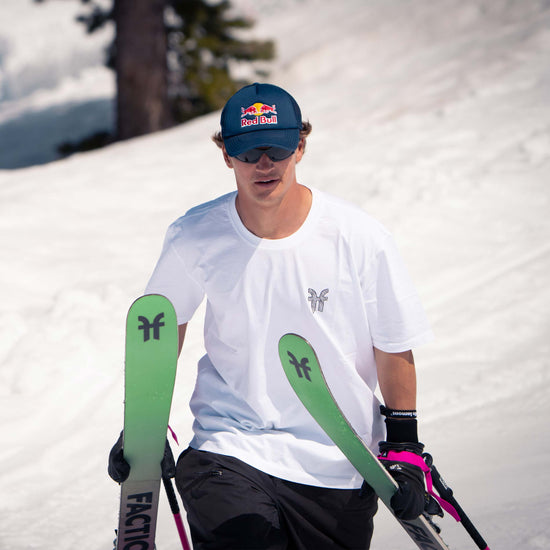 Mac Forehand Faction freestyle skier walking with white Faction t-shirt