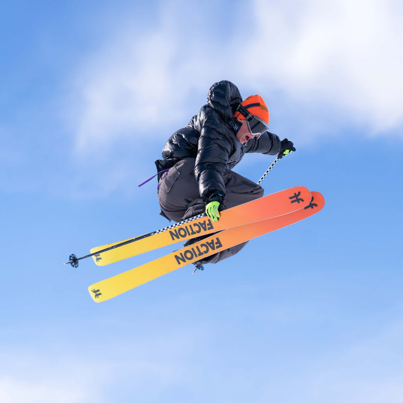 Freestyle skier jumping with black and yellow all-mountain freestyle Faction Prodigy 2 ski