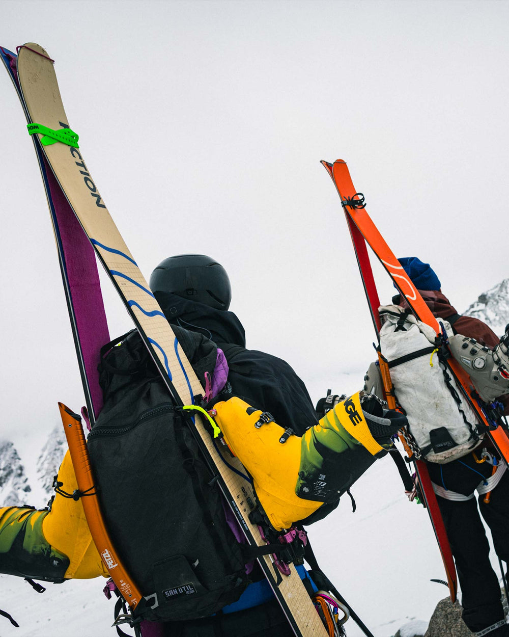 Two people with Agent skis and backpacks on a snowy mountain