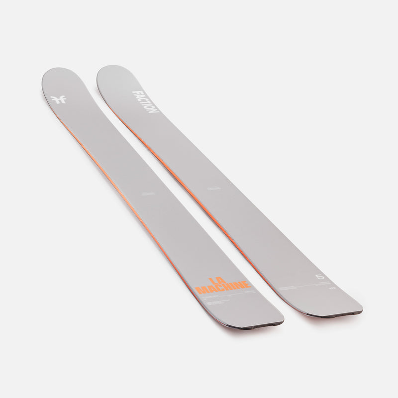 Two gray skis with orange branding on a white background