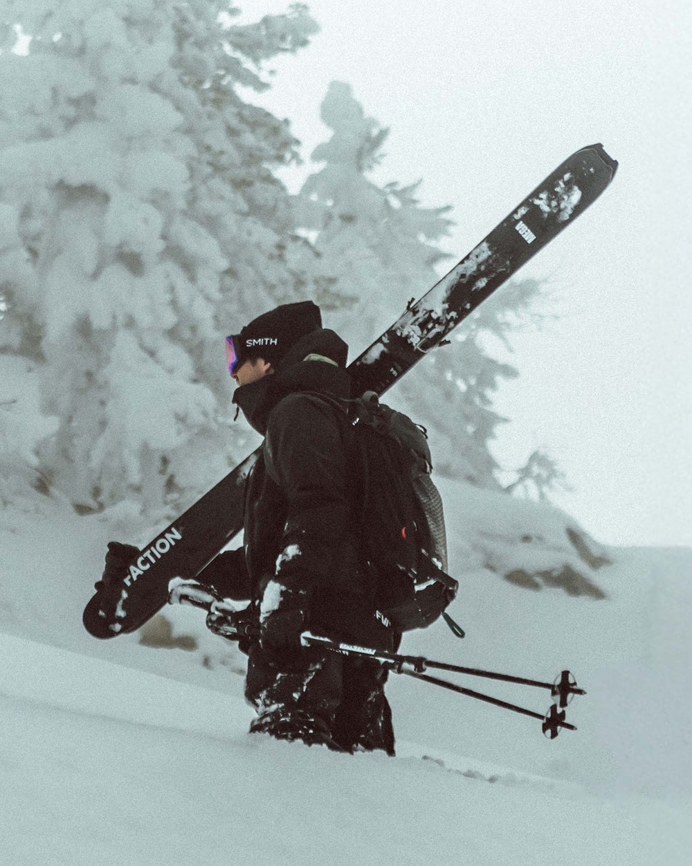 Man standing in powder with Faction La Machine powder and free touring skis