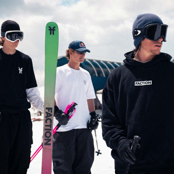 Three people in ski gear with a Faction ski and equipment on a snowy background