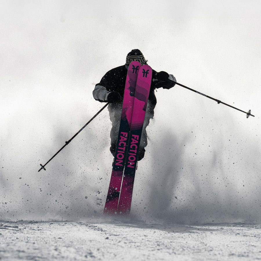 Skier showing the pink base of the Faction Prodigy 3 skis in a snowy, foggy landscape