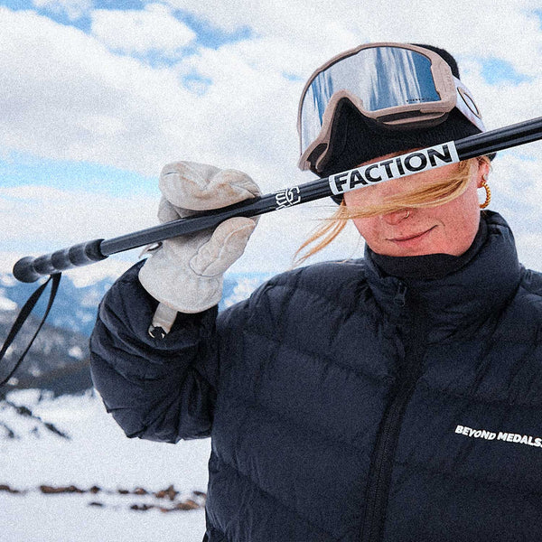 Person holding a Faction ski pole with a snowy landscape in the background